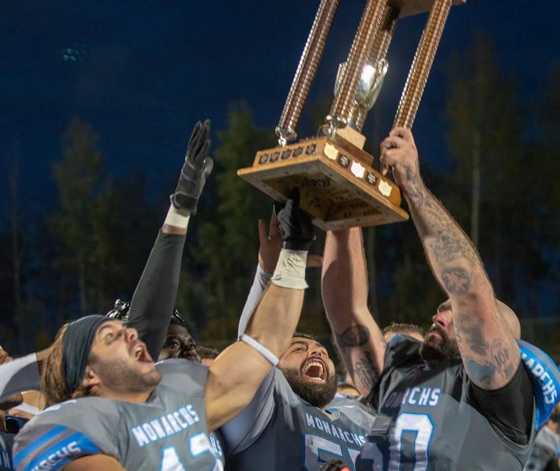 Monarchs players hoisting the championship trophy skyward