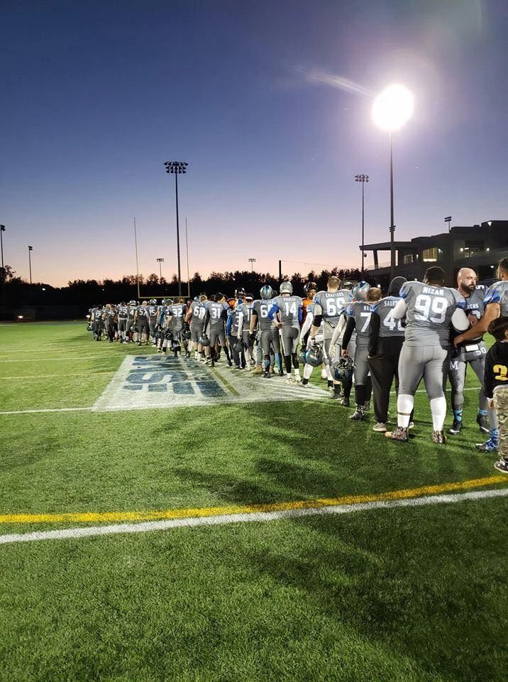 Monarchs team lined up at sunset under the stadium lights